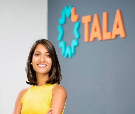 Portrait de Shivani Siroya, fondatrice et PDG de Tala, souriante devant le logo coloré de son entreprise.