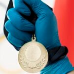 "Une médaille d'or polie arborant un blason central complexe et une couronne de laurier, symbolisant l'excellence et la réussite personnelle."