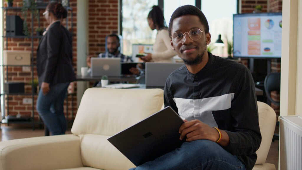 Africa’s Tech 50: Employé de bureau africain analysant des données dans un espace de coworking dynamique, représentant l'innovation au sein des startups du continent.