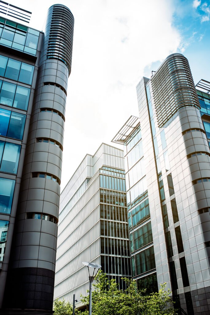 Starling Bank Fine : Vue en contre-plongée de grands immeubles commerciaux sur fond de ciel lumineux, illustrant l'architecture urbaine sophistiquée d'un centre-ville africain moderne. »