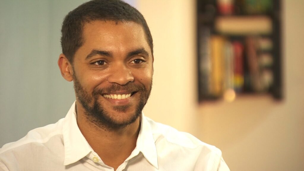 logistique: Un portrait professionnel en gros plan de l'entrepreneur tech nigérian Mark Essien souriant ; représentant le leadership dans l'écosystème des startups africaines et la croissance des plateformes numériques