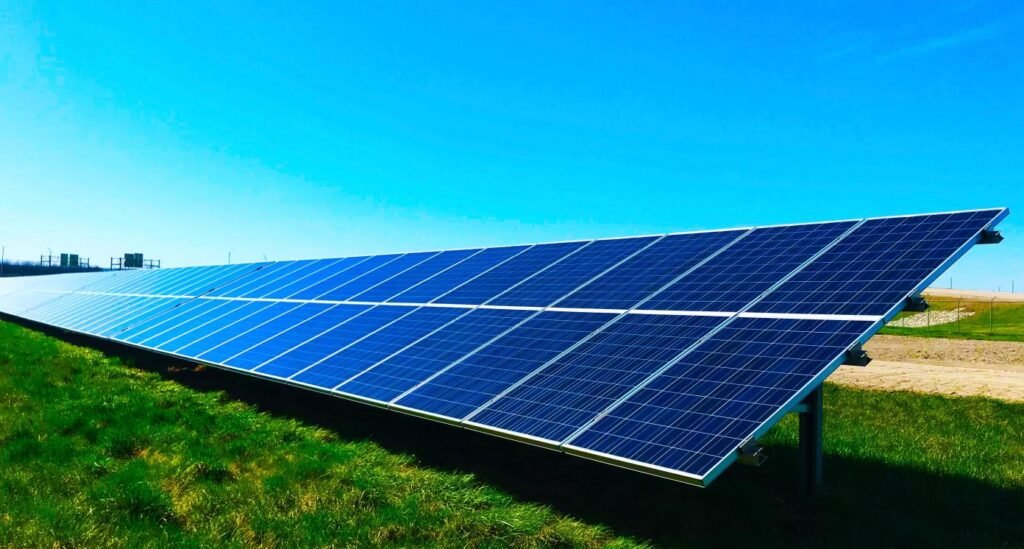 renouvelables: Une longue rangée continue de panneaux solaires à haute efficacité s'étendant à travers un champ verdoyant sous un ciel bleu clair ; représentant l'infrastructure d'énergie renouvelable à grande échelle et la voie de l'Afrique vers l'autonomie énergétique. »