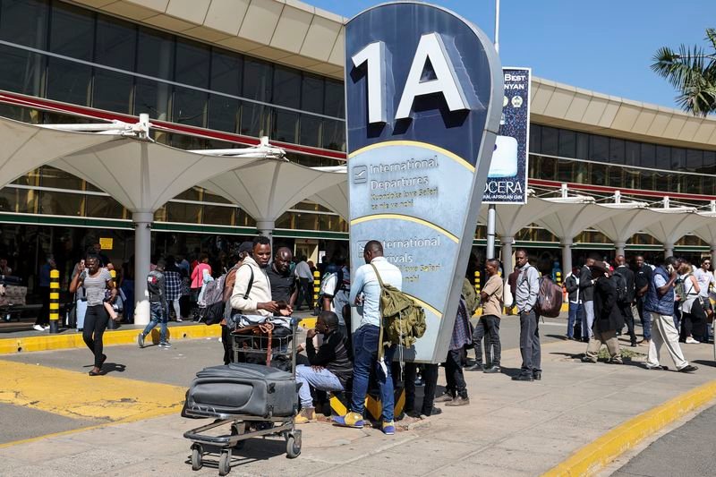 Crise : Le coup de maître des travailleurs de l’aviation kenyane qui paralyse des milliers de voyageurs à l’aéroport JKIA en 2026 crise: Voyageurs avec bagages attendant devant un terminal d'aéroport kényan très fréquenté.