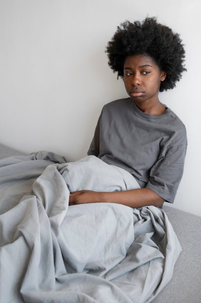 Voies respiratoires, Pourquoi cet unique et intrépide constat est un cri d’alarme pour quiconque lutte contre les troubles du sommeil en 2026 voies respiratoires: Jeune femme assise dans son lit, l'air pensive et fatiguée